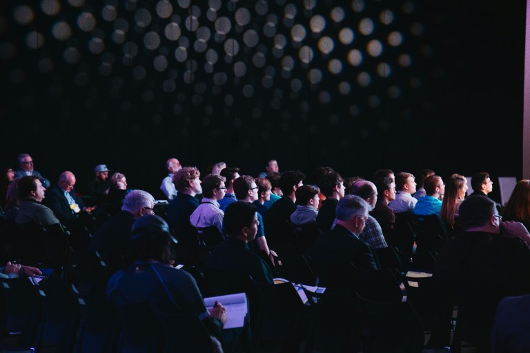 Professionals collaborating during a conference session on diversity and inclusion at work.
