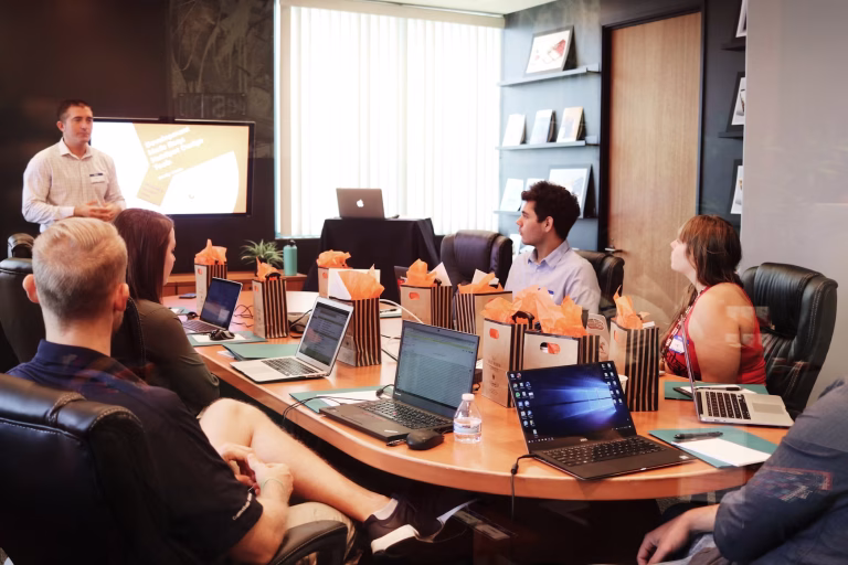 Team discussing performance improvement plan, and to incorporate a performance data recorder into their business, during a performance management meeting.