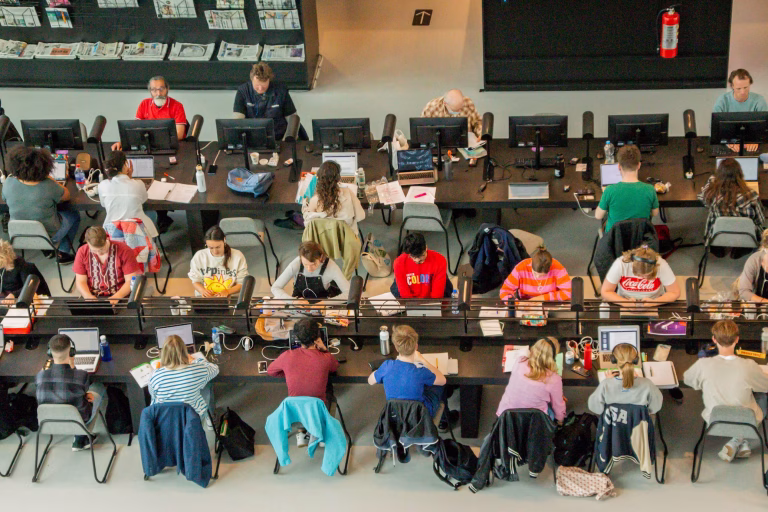 Students doing research on laptops needed for a work visa in the Netherlands after graduation, a common path for those applying for a Netherlands visa from the UK.