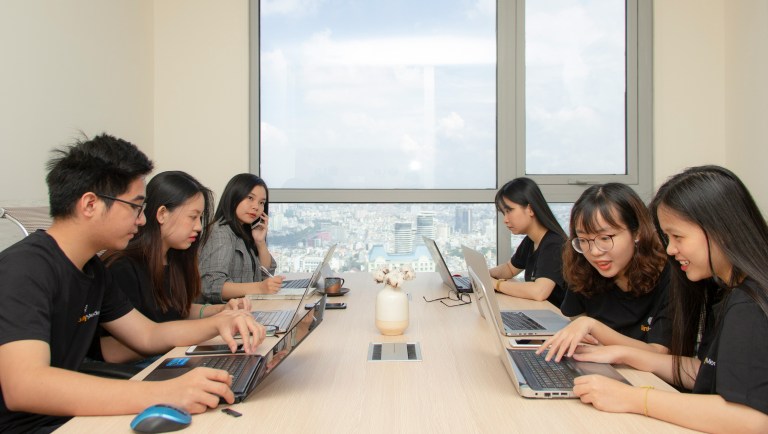 People gathered on a conference table, talking about employee benefits and compensation packages.