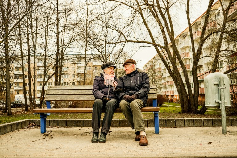 Two people sitting on a bench discussing their retirement savings, representing secure Pension Schemes in the Netherlands.