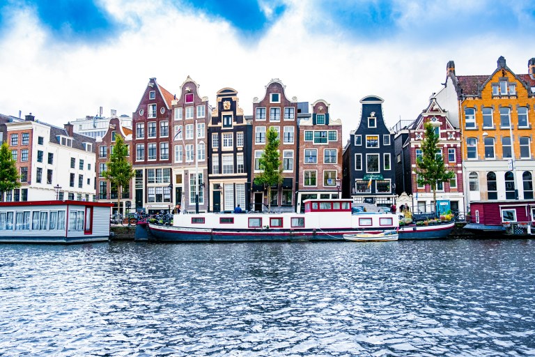 Historic Amsterdam buildings along a quiet canal, ideal for expats preparing to register a business in the Netherlands.