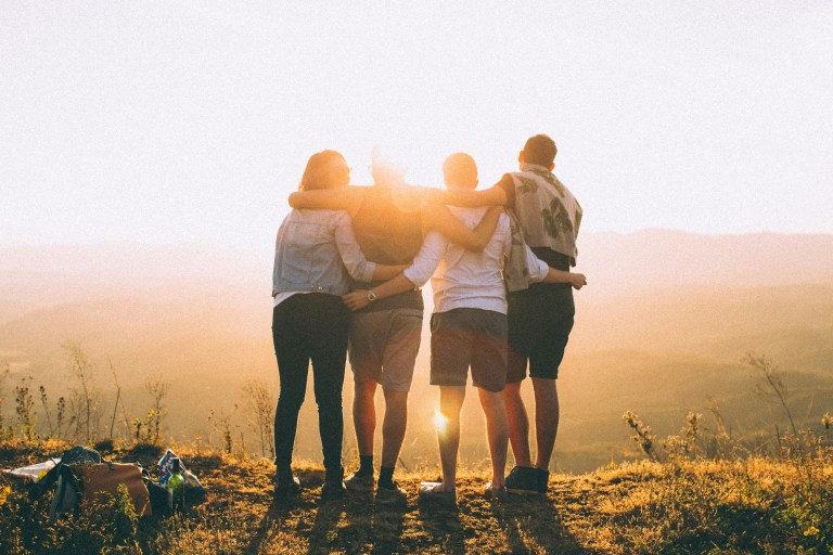 Employees hugging in the sun, demonstrating connection and the impact of staff skills training on human relationships.