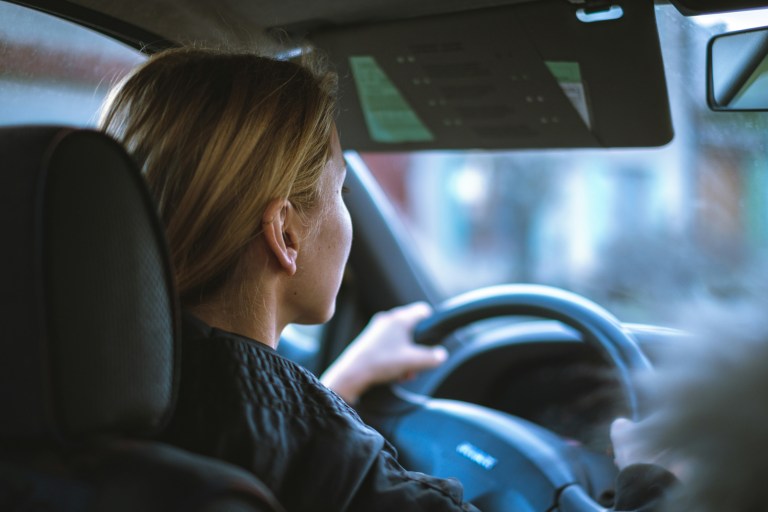 Expat driving a car with her new drivers license in the Netherlands.